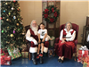 Boy sitting in Santa's lap and Mrs. Claus. 