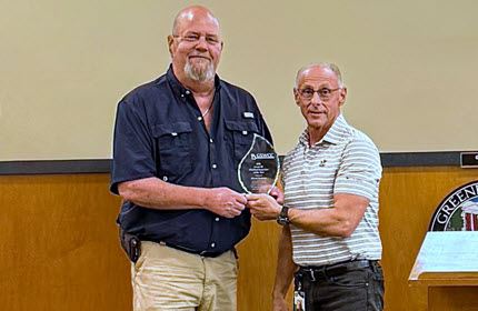 Gary presenting David with a plaque